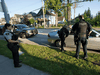 Members of the RCMP Gang Enforcement Team is silhouetted as he speaks to the occupants of a car during a stop in Surrey, B.C.