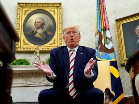 U.S. President Donald Trump answers questions while sitting in front of paintings of former U.S. presidents George Washington and Thomas Jefferson during his meeting with Romania's President Klaus Iohannis in the Oval Office of the White House in Washington, U.S. August 20, 2019. (REUTERS/Kevin Lamarque)