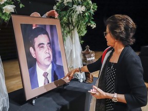 Neena Obhrai looks at a photo of her late husband Deepak Obhari at a memorial celebrating his life in Calgary, Alta., Monday, Aug. 26, 2019.THE CANADIAN PRESS/Jeff McIntosh