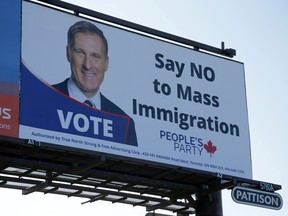 A billboard featuring the portrait of People’s Party of Canada (PPC) leader Maxime Bernier and its message "Say NO to Mass Immigration" is displayed in Toronto.
