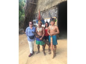 Lesya Sabada stands with the Chief of a Tatuya Tribethat lives deep in the Amazon rain forest and two of his children. (Supplied photo) (For Darlene Polachic column)