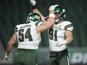 University of Saskatchewan Huskies defensive linemen Evan Machibroda, left, and Riley Pickett celebrate during Friday's 44-9 victory over the University of Regina Rams.