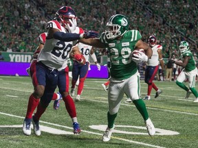 Saskatchewan Roughriders running back William Powell, 29, fends off Montreal Alouettes linebacker Bo Lokombo during Saturday's CFL game at Mosaic Stadium.