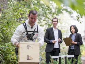 Research fellow David Kingston, left, demonstrates the use of an exoskeleton designed to help reduce injuries as Dr. Catherine Trask, middle, and Research fellow Ornwipa Thamsuwan observe. Photo taken in Saskatoon, SK on Thursday, September 26, 2019.