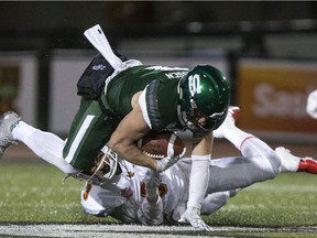 Huskies WR Colton Klassen is stopped by Dinos defensive back Jacob Biggs on Friday, Sept. 27, 2019.