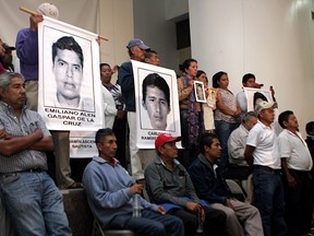In this Oct. 29, 2014, file photo, parents and relatives of 43 missing students in Guerrero state listen during a press conference offered after a meeting with Mexico's then-president Enrique Pena Nieto in Mexico City.