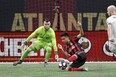 Atlanta United midfielder Gonzalo Martinez falls as he moves in for a shot against TFC goalkeeper Quentin Westberg in Atlanta last night.  the associated press