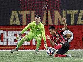 Atlanta United midfielder Gonzalo Martinez falls as he moves in for a shot against TFC goalkeeper Quentin Westberg in Atlanta last night.  the associated press
