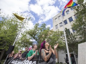 Melissa Squire, right, with other members of Saskatoon Pride, applaud as the Pride flag is raised at city hall in Saskatoon, Sask. June 11, 2018.