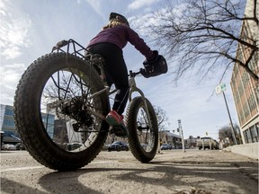 A cyclist in a protected bike line on 23rd Street East in Saskatoon.