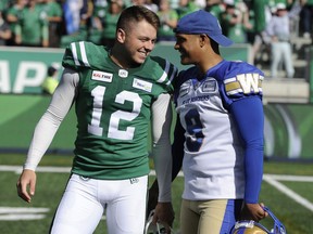 Winnipeg Blue Bombers kicker Justin Medlock, right, congratulates Brett Lauther after the Roughriders' kicker made a game-winning field goal in the Labour Day Classic on Sept. 1.
