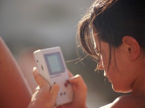 A woman plays on her game boy.