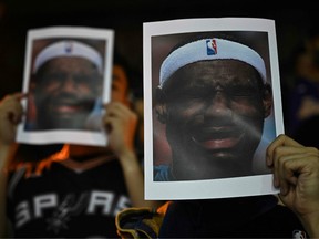 Protesters hold photographs of Lakers forward LeBron James grimacing, at the Southorn Playground in Hong Kong on October 15, 2019.
