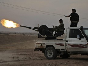 Turkish-backed Syrian fighters fire a truck mounted heavy gun near the town of Tukhar, north of Syria's northern city of Manbij, on Monday, Oct. 14, 2019.