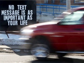 Motorists make their way past an anti-distracted driving sign outside the EPS West Division police station in Edmonton. Saskatchewan Government Insurance on Nov. 25, 2019 says police handed out 1,290 tickets for distracted driving in October. (David Bloom / Postmedia Network)