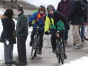 Cyclists try to manoeuvre past people standing on the Meewasin Trail in Saskatoon on March 15, 2017.