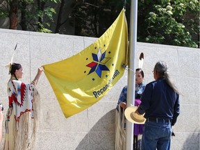Attendees work together to raise the Reconciliation Flag at Saskatoon City Hall on May 29, 2018.