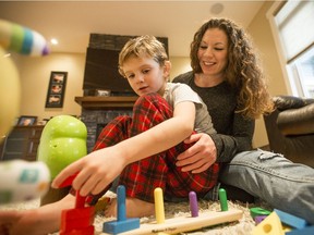 Trystan and Amy Shout play with toys in their home.