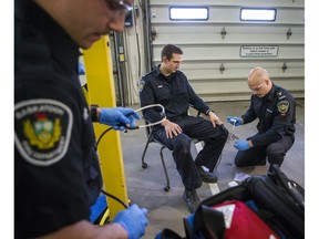 From left to right, Saskatoon firefighters Carter Tomyn, Marc Zimmer and Barret Husulak demonstrate how Penthrox and other life-saving medications are administered, at Fire Station No. 1 in Saskatoon on Nov. 14.