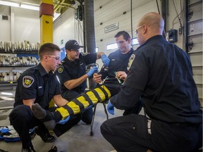 From the left, Saskatoon firefighters Carter Tomyn, Steve Killick, Marc Zimmer and Barret Husulak demonstrate how Penthrox and other life-saving medications are administered, at Fire Station No. 1 in Saskatoon on Nov. 14.