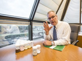 Saskatchewan Research Council CEO Mike Crabtree in his Innovation Place office. The jars on the table contain rare earth elements.