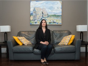 Julie Eisler, a Superhost on Airbnb, sits on the sofa inside a home she rents out using the service.