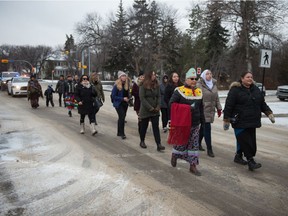 A group of people march down Legislative Drive demanding an end to forced sterilization of Indigenous women and girls.