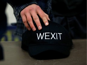 A supporter holds his Wexit hat while attending a rally for Wexit Alberta, a separatist group seeking federal political party status, in Calgary, Alberta, Canada November 16, 2019.  REUTERS/Todd Korol