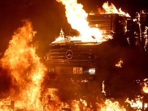 A police vehicle catches fire after being hit with Molotov cocktails, as anti-government protesters clash with police, outside Hong Kong Polytechnic University in Hong Kong, November 17, 2019. (REUTERS/Athit Perawongmetha)