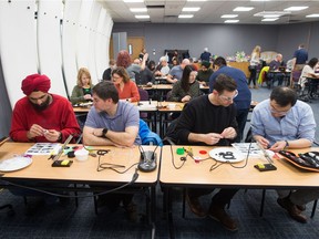 Volunteers wire pressure switches to be used in the modification of toys for disabled children at the SaskPower building on Victoria Avenue in Regina, Saskatchewan on December 6, 2019. The toys were being modified as part of a build event put on by the Neil Squire Elves and SaskPower as a way to allow skilled people to volunteer their time to produce toys that can be given to children with disabilities.