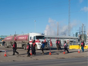 Locked out Unifor workers stand on a picket line while a semi truck waits at the Co-op refinery in Regina, Saskatchewan on Dec. 10, 2019.