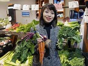 Mirjana Valdes, a food researcher at the University of B.C., holds handfuls of vegetables at the Lonsdale Quay Market.