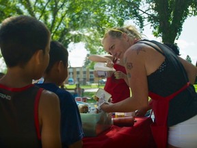 Candace Gabriel hands out lunch in a park.