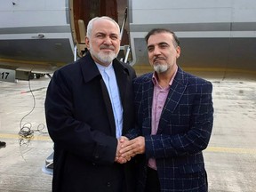 A handout picture released by the Iranian Foreign Minister's official Twitter account on Saturday, Dec. 7, 2019, shows Foreign Minister Mohammad Javad Zarif (left) and Iranian scientist Massoud Soleimani standing by a plane at an undisclosed location.