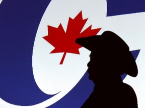 A forum visitor is silhoutetted in front of a projected logo before a Conservative party leadership candidate forum at the Deerfoot Inn and Casino in Calgary, Alta. on Wednesday March 1, 2017.