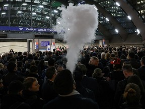 A man smokes A man smokes an e-cigarette in the queue to Canary Wharf tube station in London, November 27, 2019. (REUTERS/Kevin Coombs)