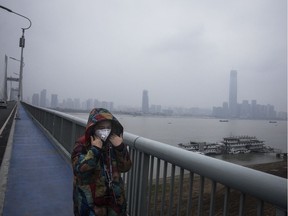 A woman wears a protective mask as she walks across the Yangtze River Bridge on January 27, 2020 in Wuhan, China