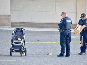 Greater Sudbury Police officers collect evidence at the site of a stabbing incident June 3 outside the Michaels store on Marcus Drive. A woman and child were injured, while the suspect, a man, also injured himself, police said. Jim Moodie/Postmedia