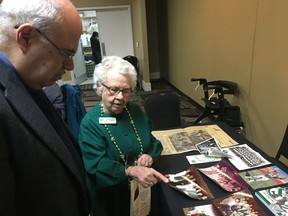 Amber MacLeod, right, shows her collection of Saskatchewan Roughriders memorabilia to Will Chabun at a Canadian Club of Regina luncheon on Thursday at the Royal Hotel Regina.