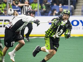 Saskatchewan Rush transition player Mike Messenger runs the ball under pressure from Colorado Mammoth forward Chris Wardle during first half action in Saskatoon on Saturday, January 18, 2020.