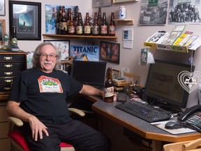 Beer historian Bert Barkwell, who collects and documents beer labels, sits at his work station in his home on the edge of Pasqua Lake. His hand is resting on a vintage bottle from the Regina Brewing Company.