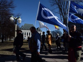 The regional Metis presidents of Ontario, Alberta and Saskatchewan are calling for reform of the Metis National Council, raising serious concerns about "dysfunction" and about a lack of transparency involving financial and administrative matters within the national body. David Chartrand, president of the Manitoba Metis Federation, middle, carries the Metis flag as he and fellow Metis Federation leaders and delagates march to the Supreme Court of Canada in Ottawa, Thursday, April 14, 2016.