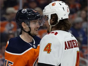 The Edmonton Oilers' Josh Archibald (15) goes visor to visor with the Calgary Flames' Rasmus Andersson (4) during first period NHL action at Rogers Place, in Edmonton Wednesday Jan. 29, 2020.