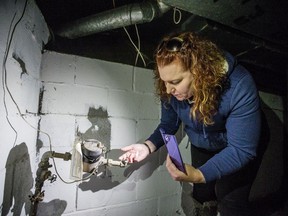 Alisa Thompson of Epic Alliance inspects a vandalized copper pipe from a water meter. Theft of copper wire and pipes is a recurring problem in houses that are under construction or vacant, resulting in damage and potential flooding or gas leaks. (Matt Smith / Saskatoon StarPhoenix)