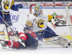 Lethbridge Hurricanes forward Brett Davis is tripped in front of the net of Saskatoon Blades goaltender Nolan Maier during WHL action at SaskTel Centre in Saskatoon on Saturday, February 1, 2020. Blades defenceman Radek Kucerik, left in photo, was given a penally for tripping.