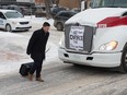 A man crosses the street in front of a Co-op semi truck, which was part of a large convoy on Victoria Avenue in Regina, Saskatchewan on Feb. 6, 2020. BRANDON HARDER/ Regina Leader-Post