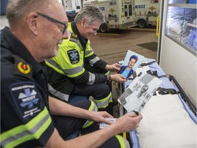 Martin Bowman, right, and Randy Erickson, both paramedics celebrating 40 years with the Medavie Health Services, look at photos of themselves from when they began their careers at the Michael Dutchak Centre in Saskatoon, SK on Wednesday, February 5, 2020.