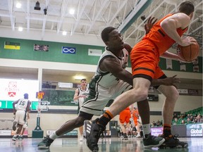 University of Saskatchewan Huskies guard Emmanuel Akintunde reaches through the legs of Thompson Rivers University WolfPack guard Michael Rouault for the ball during a one-game play-in contest to see who advances to the Canada West quarterfinals at the PAC on the U of S campus in Saskatoon, SK on Friday, February 14, 2020.