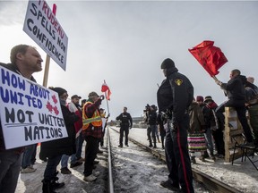 Saskatoon police monitor as people confront a group gathered in solidarity with the Wet'suwet'en hereditary chiefs, setting up a demonstration along a section of railway in between 20th Street West and 21st Street West on Avenue I  in Saskatoon on Feb. 22, 2020