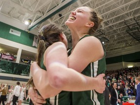 University of Saskatchewan Huskies forward Summer Masikewich, right, hugs guard Libby Epoch after defeating the University of Alberta Pandas in the Canada West women's basketball conference final on Feb. 28.